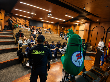 Charla en auditorio con policía y mascota